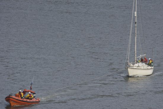 31ft yacht under tow by RNLI Dart, being returned to its moorings up river.